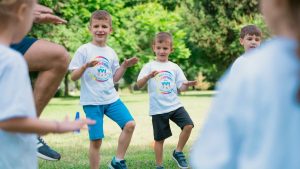 Joyful kids engaging in playful activities in a sunny park, enjoying summer fun together.